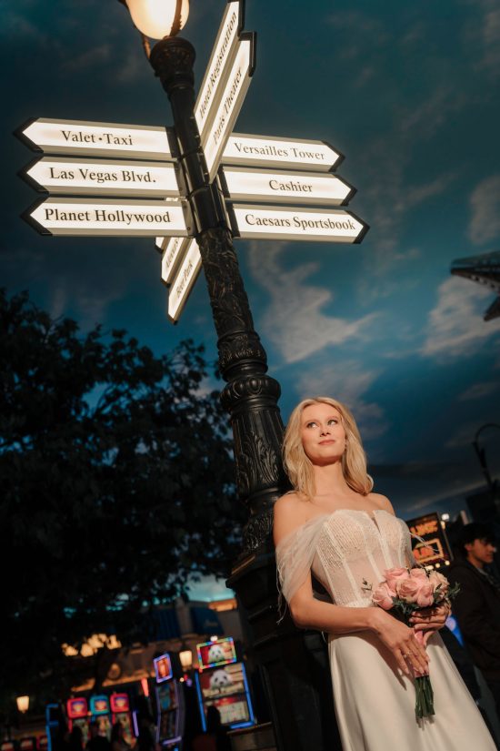 Bride posing beneath the iconic Paris Las Vegas street sign during a luxury Las Vegas elopement