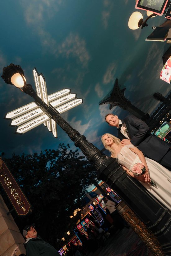 Bride and groom beneath the iconic Paris Las Vegas ceiling and Eiffel Tower during a luxury elopement