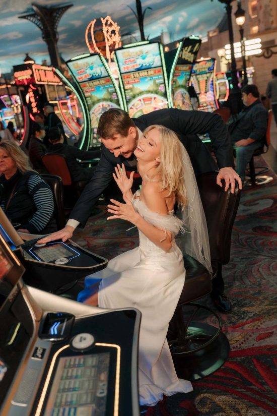 Bride and groom playing slot machines inside Paris Las Vegas during their luxury elopement