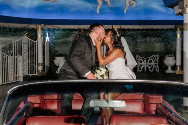 Bride and groom kissing in the Pink Cadillac at Little White Chapel in Las Vegas