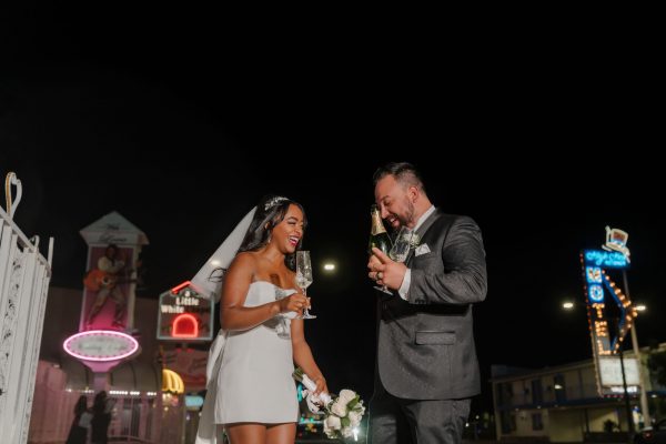 Bride and groom celebrating outside Little White Chapel at night in Las Vegas after their wedding ceremony