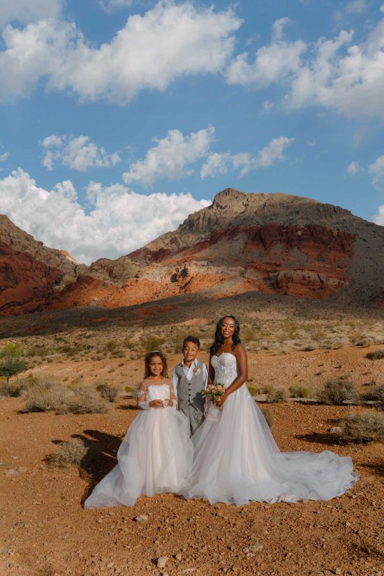 Bride with her children during a sunrise wedding portrait session at Calico Basin in Red Rock Canyon near Las Vegas