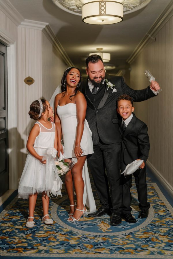 Happy wedding couple with children celebrating in a hotel hallway after their Las Vegas wedding ceremony