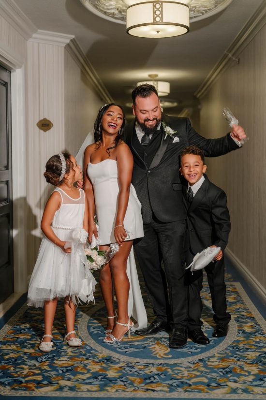 Happy wedding couple with children celebrating in a hotel hallway after their Las Vegas wedding ceremony